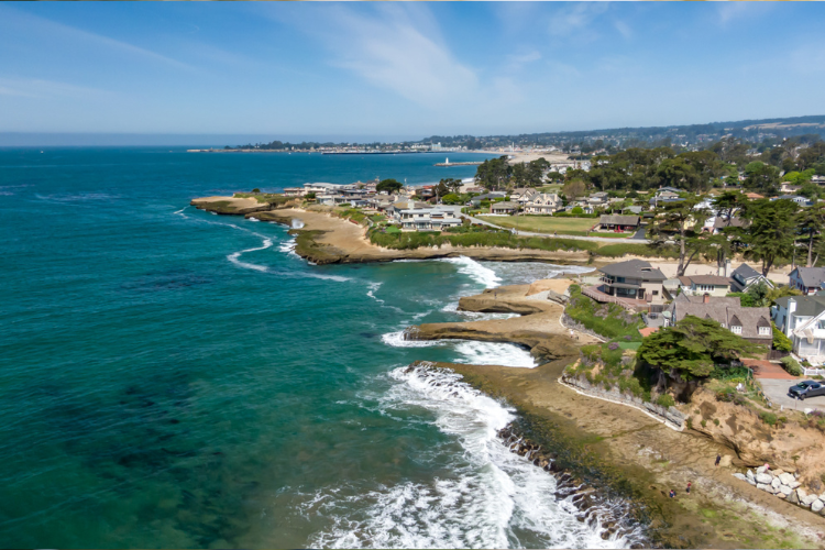 Aerial view of coastal homes along the Santa Cruz California shoreline, highlighting the desirable oceanfront neighborhoods and strong real estate demand that influences home values in the Santa Cruz housing market.