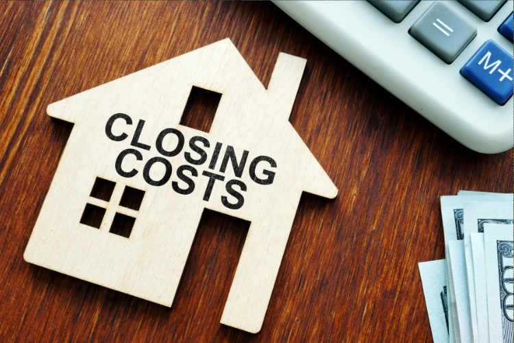 Close-up of a "Closing Costs" wooden icon and financial tools, representing the final stage of escrow. Ideal for Santa Cruz homebuyers calculating drainage, roofing, and foundation repair budgets.