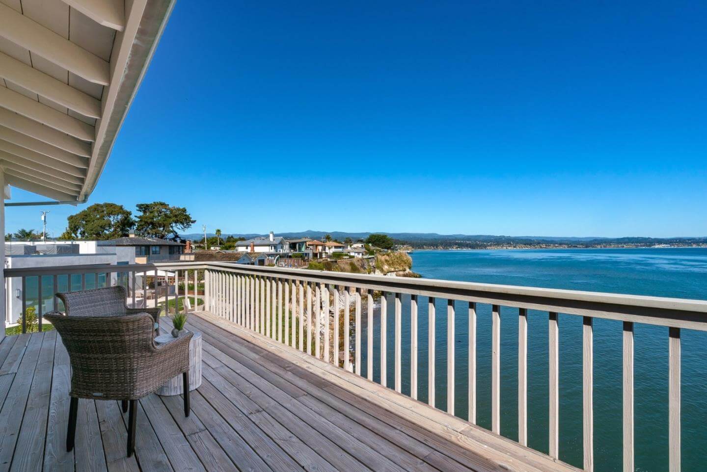 Santa Cruz Ocean View Deck With Coastal Outdoor Living Space Santa Cruz ocean view deck with wood railing, outdoor seating, blue sky, and wide Monterey Bay coastline views. This coastal Santa Cruz property feature highlights the outdoor living space, water views, natural light, and buyer-friendly deck area that can help a home stand out among Santa Cruz properties.