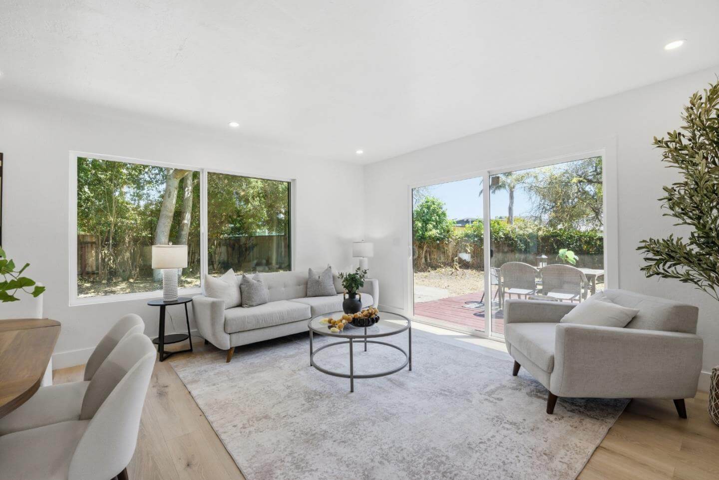 Staged Santa Cruz Living Room With Natural Light and Backyard Access Bright staged living room in a Santa Cruz single-family home with large windows, neutral furniture, natural light, sliding glass doors, and backyard access, showing the clean presentation and indoor-outdoor appeal that can help Santa Cruz home sellers attract strong buyer interest and better offers.