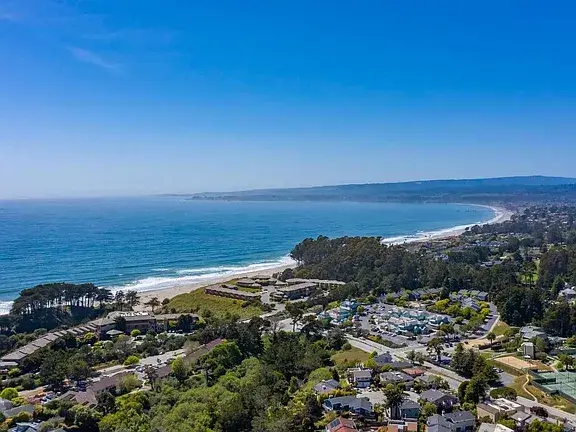 Aptos California Coastal Homes With Oceanfront View Aerial view of the Aptos, California coastline showing residential neighborhoods, landscaped properties, coastal roads, and a wide Pacific Ocean beach, illustrating the oceanfront setting and housing options found in Santa Cruz County.