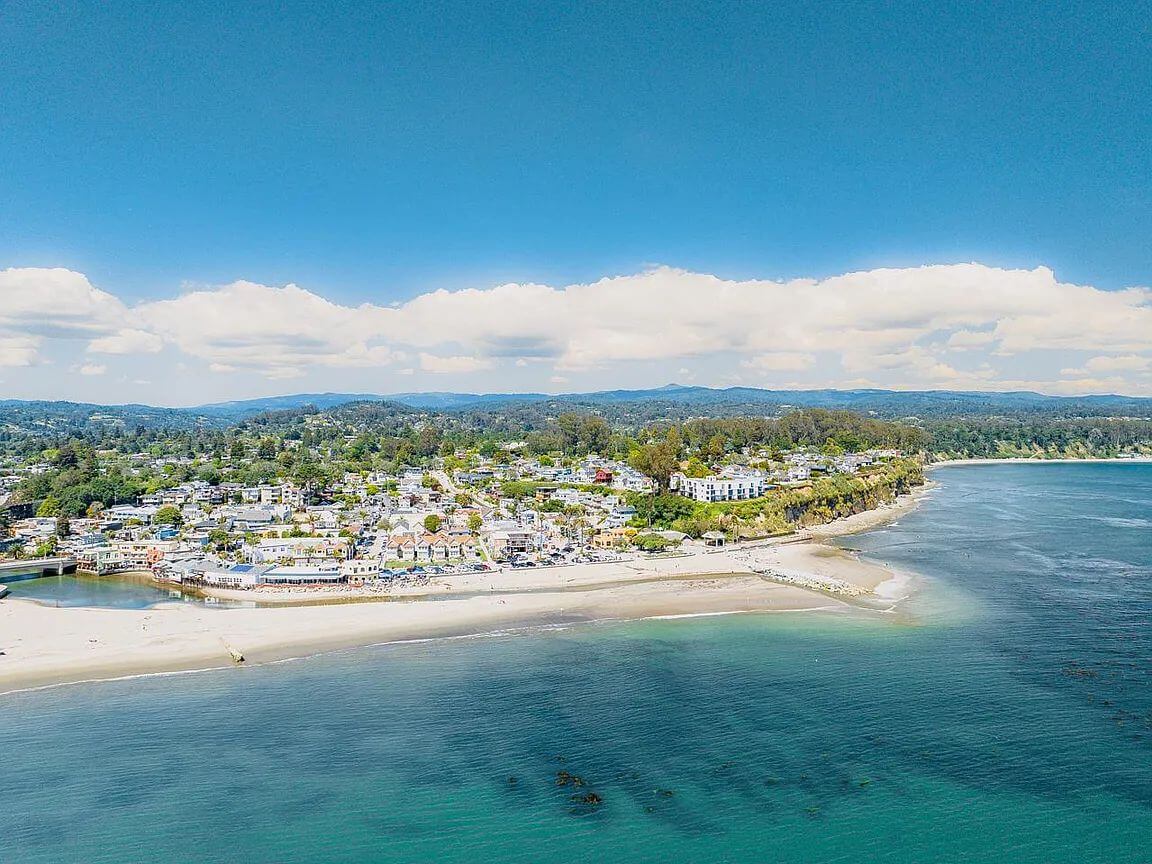 capitola-village-beach-aerial-santa-cruz-county Aerial view of Capitola Village and Capitola Beach in Santa Cruz County, showing coastal homes, beachfront buildings, the shoreline, and Monterey Bay.